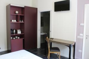 a bedroom with a desk and a tv on a wall at Cetara Costa d'Amalfi Residence in Cetara