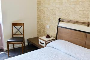 a bedroom with a bed and a chair at Cetara Costa d'Amalfi Residence in Cetara