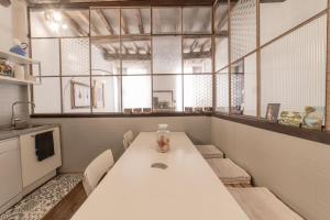a kitchen with a white table with chairs and a window at casa sangiacomo quattro in Modena