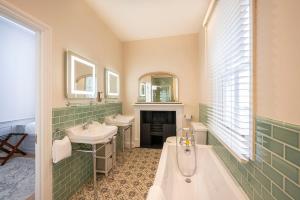 a bathroom with two sinks and a tub and mirrors at Eight in Bath