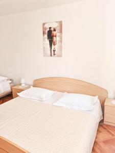 a bed in a bedroom with a picture on the wall at Holiday home Srdašce in Perković