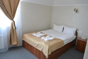 a bedroom with a bed with two white towels on it at Три Сімки in Vyshhorod