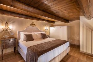 a bedroom with a large bed and wooden ceilings at Saint George's House Appartamenti & Spa in Pachino +81 photos