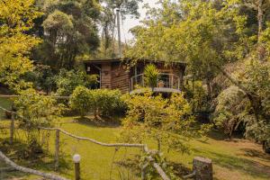 a log cabin in the middle of a garden at Pousada Uma Ilha Na Montanha in Campos do Jordão