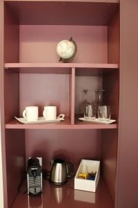 a shelf with a clock and some cups and dishes at Cetara Costa d'Amalfi Residence in Cetara