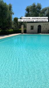 uma grande piscina de água azul em frente a um edifício em Sweet Home Suite em Fasano