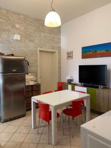 una cucina con tavolo bianco e sedie rosse di Casa Ridente: Porto Cesareo Centro a Porto Cesareo