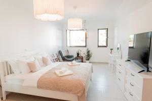 1 dormitorio blanco con 1 cama grande y TV en Kuća u centru en Pakoštane