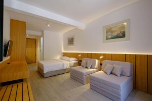 a hotel room with two beds and a couch at Dubrave apartmani in Budva