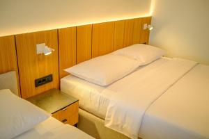 a bedroom with two beds and a headboard at Dubrave apartmani in Budva