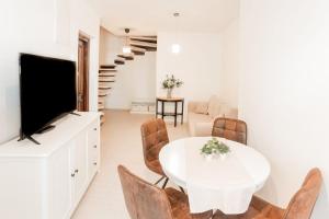 a living room with a white table and chairs and a television at Kuća u centru in Pakoštane