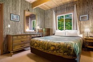 a bedroom with a bed and a dresser and a mirror at Yakima River Cabin in Cle Elum