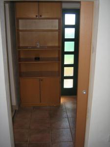 a kitchen with wooden cabinets and a door to a hallway at Apartment Tomato in Pula