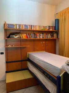 una camera con letto e mensola con libri di Casa Ridente: Porto Cesareo Centro a Porto Cesareo