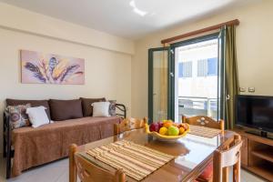sala de estar con sofá y mesa con un bol de fruta en Mary's Apartments, en Argostoli