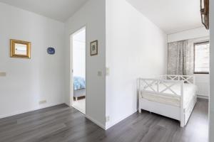 a white bedroom with a bed and a mirror at Riverside Apartment Rovaniemi in Rovaniemi