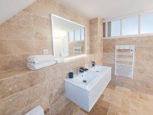 La salle de bains est pourvue d'un lavabo blanc et d'un miroir. dans l'établissement Le Huis Clos, à Amboise