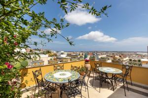 two tables and chairs on a balcony with a view at Saint George's House Appartamenti & Spa in Pachino