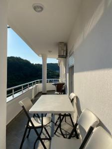 a table and chairs on a balcony with a view at Apartments Gjenashaj in Ulcinj