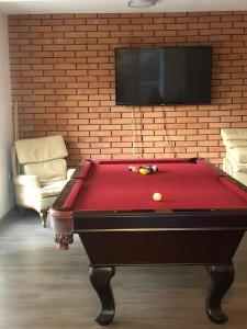 a red pool table in a room with a tv at Casa Jardin Rosarito in Rosarito