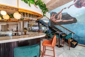 a bar with green chairs and a staircase at AP Eva Senses in Faro