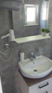 a bathroom with a white sink and a mirror at Rooms Korina & Mauro Ropa Mljet in Ropa +15 photos