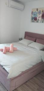 uma cama com dois bichos de peluche cor-de-rosa em Rooms Korina & Mauro Ropa Mljet em Ropa