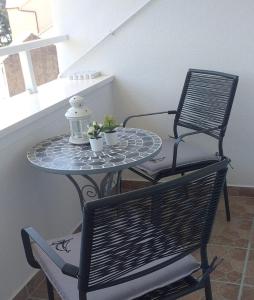 una mesa con dos sillas y una mesa con dos plantas. en Rooms Korina & Mauro Ropa Mljet en Ropa