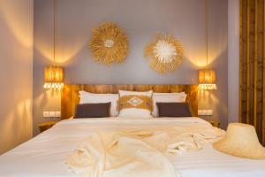 a bedroom with a large white bed and two mirrors at studio lefkes kea in Vourkari