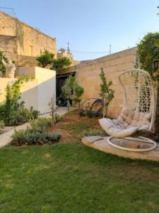 un jardín con una silla blanca en el césped en Villa Mosta, en Mosta