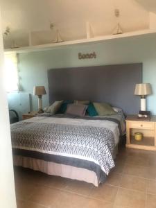 a bedroom with a bed and two tables and two lamps at Casa Jardin Rosarito in Rosarito