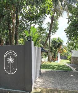 una puerta en la entrada de un complejo con palmeras en Kanferri Villa, en Ahangama