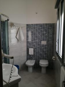 La salle de bains est pourvue de toilettes, d'un bidet et d'un lavabo. dans l'établissement B & B Conchiglie, à Gallipoli