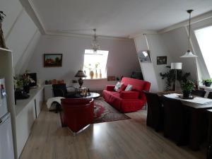 a living room with a red couch and a table at Het Speijerhuis in Harlingen