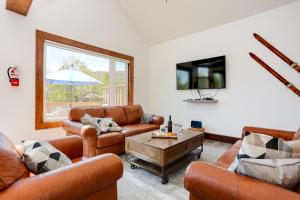 a living room with leather furniture and a tv at Luxury Mountain Retreat with private hot tub 82958 in Blue Mountains