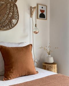 Cama con almohada marrón y lámpara en Kanferri Villa, en Ahangama