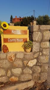 a sign for a county house on a stone wall at Elaia country living in Galatas