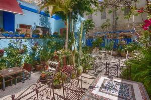 un jardín con muchas plantas, mesas y sillas en Port Inn, en Haifa