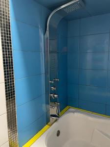 リマにあるHotel Manantial No,001の青いタイルのバスルーム(バスタブ付)