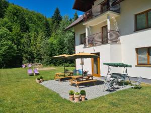 Casa con patio con bancos y sombrillas en Hołdysówka przy Gondoli, en Szczyrk