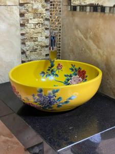 a yellow bowl with flowers on it sitting on a counter at Hotel Manantial No,002 in Lima