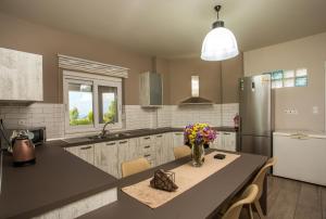 a kitchen with a table with a vase of flowers on it at AGGELOS GARDEN VIEW in Faliraki