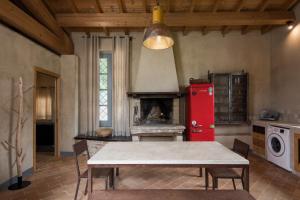 eine Küche mit einem Tisch und einem roten Kühlschrank in der Unterkunft BED&BEER BIRRIFICIO LA GRAMIGNA in Perugia