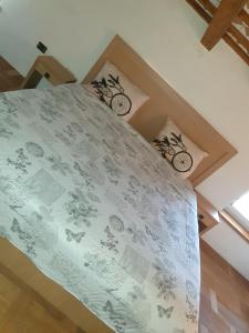 1 dormitorio con 1 cama con edredón blanco en Šmartno Apartmaji Goran, en Kojsko