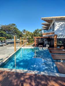 una piscina de agua azul frente a un edificio en Passagem Concept Hotel e Spa en Cabo Frío