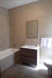 a bathroom with a sink and a tub and a toilet at Rabat Falcon Apartment in Rabat