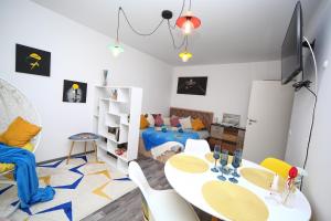 a room with a table and chairs and a bed at B&M Apartment in Braşov