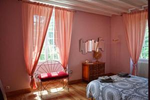 um quarto com uma cama, uma cadeira e uma janela em Maison Matachot em Orthez