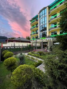 a building with a garden in front of it at Hotel Condori in Kobuleti