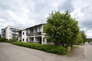 an apartment building with a tree in front of it at Riverside Apartment Rovaniemi in Rovaniemi